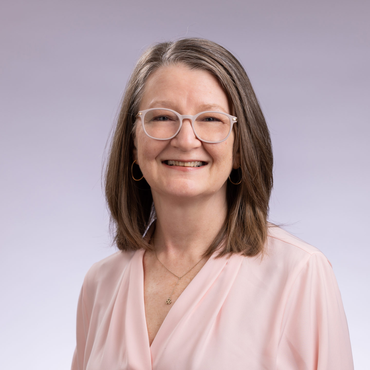 Professional photo of Maureen Green in a pink shirt in front of a white background