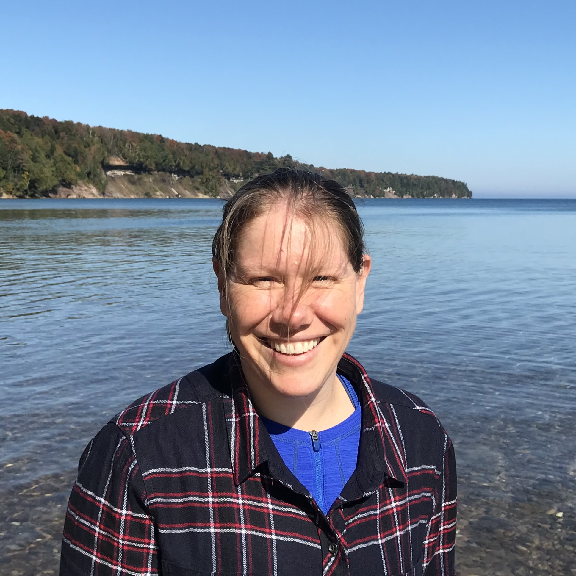 Informal photo of Caroline Freitag standing in front of the water with land in the background