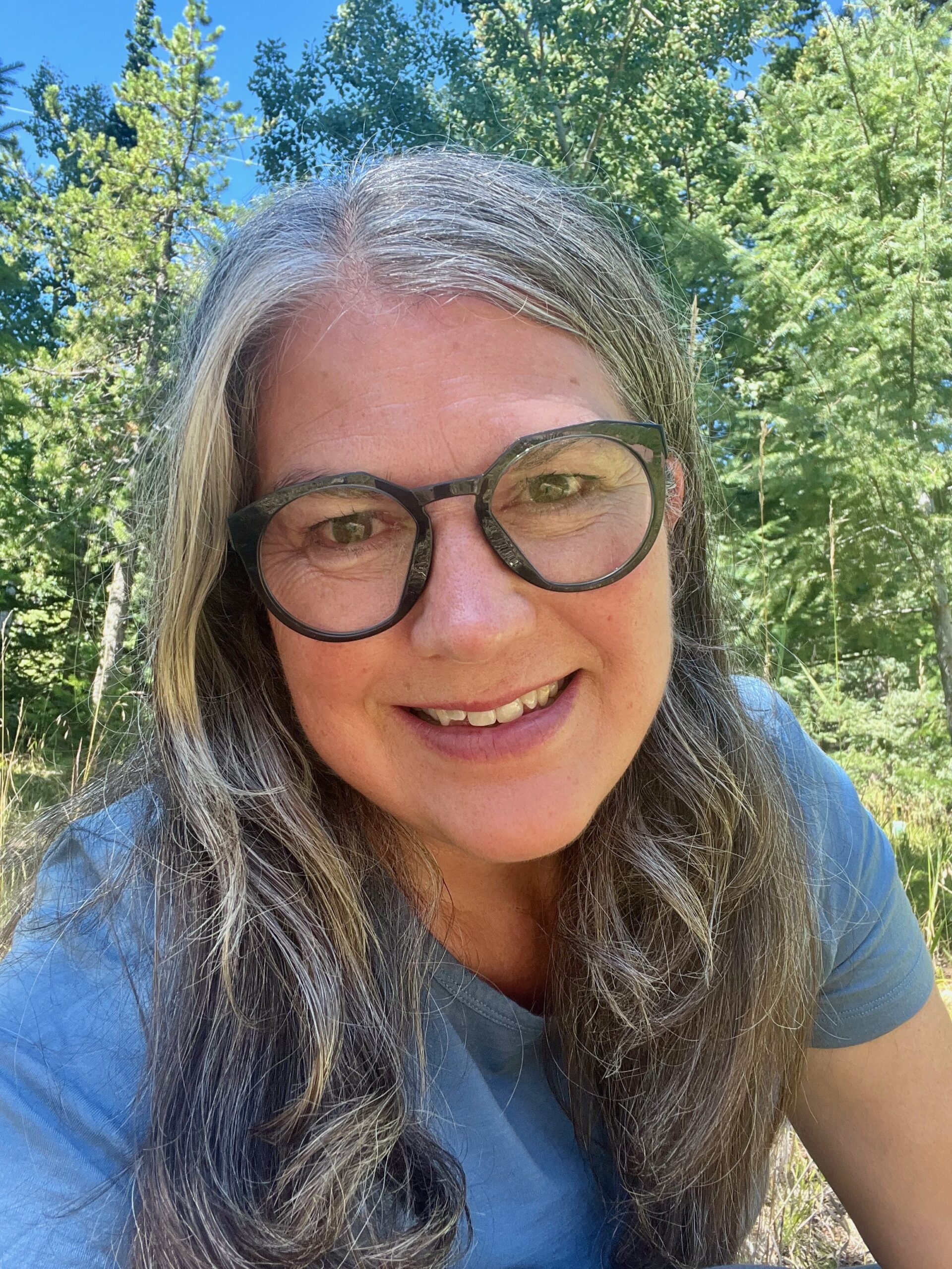 Professional photo of Cheryl Manning in front of greenery