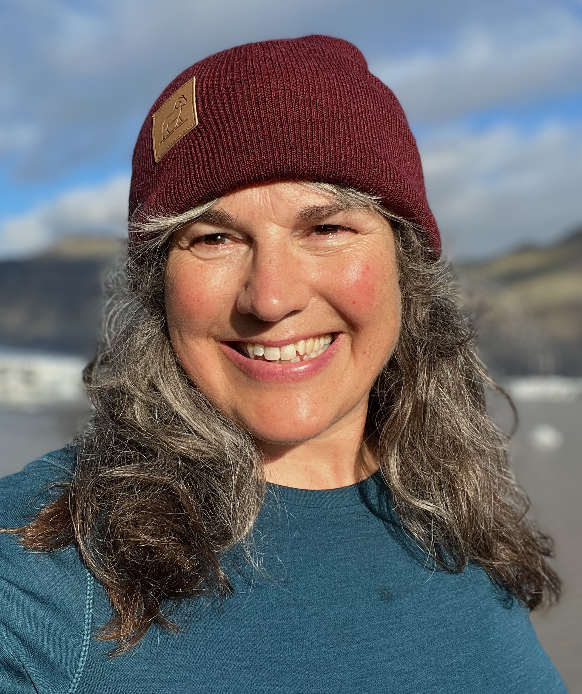 An informal headshot of Cheryl Manning wearing a red beanie.