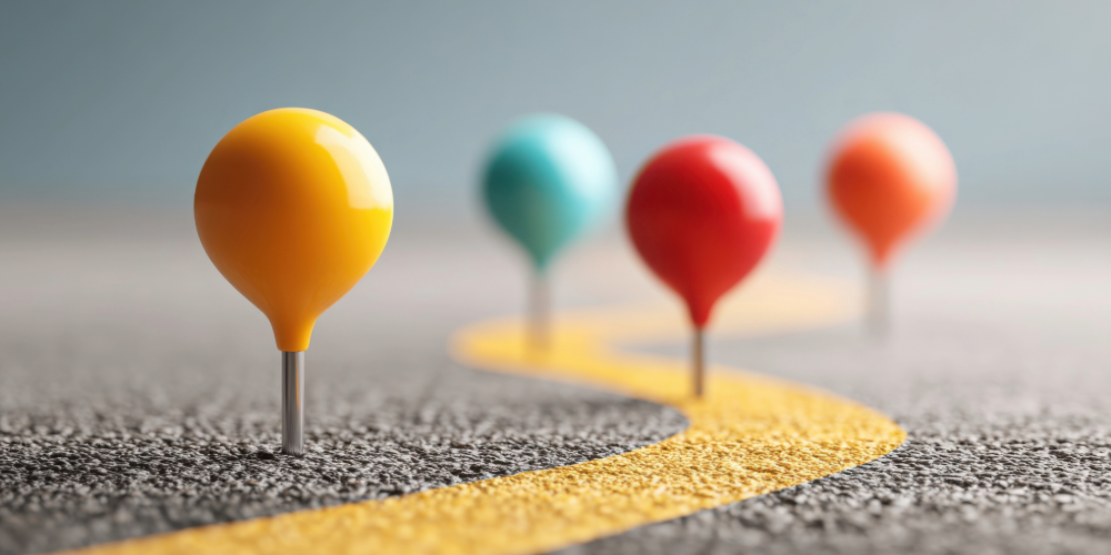 Image of a paved road with multi colored push pins throughout